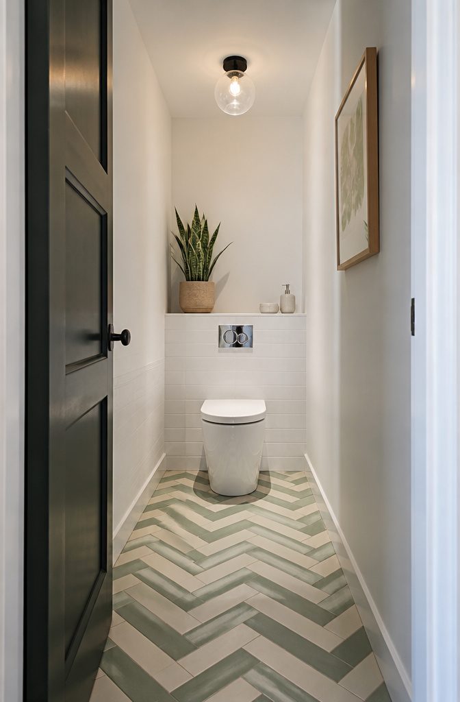 A closet toilet with bold patterned vinyl flooring in green and cream.