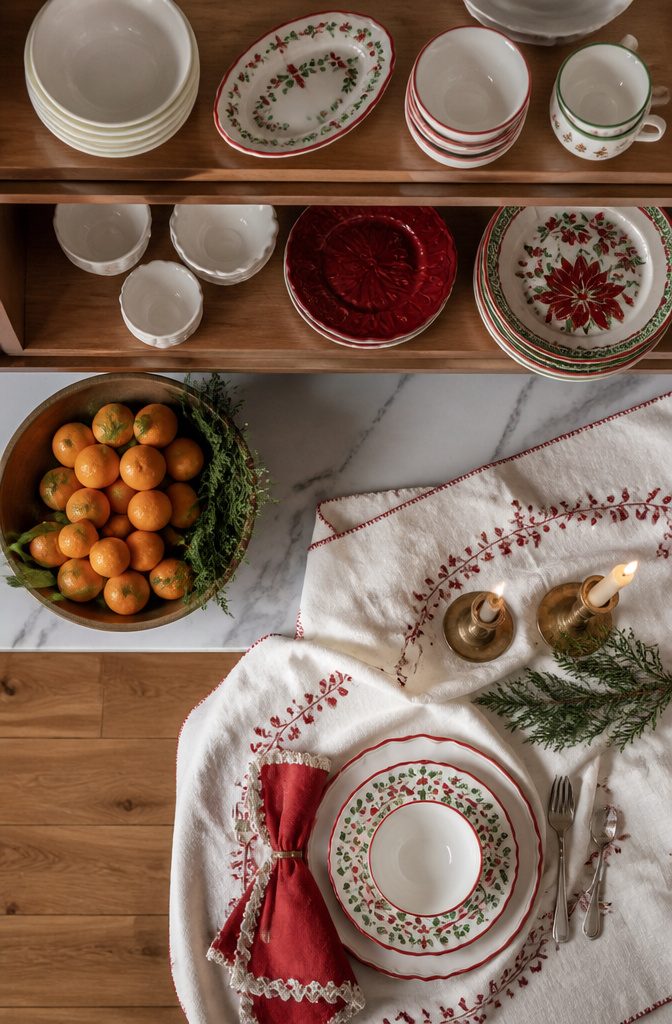 Christmas plates and bowls displayed on kitchen shelves.