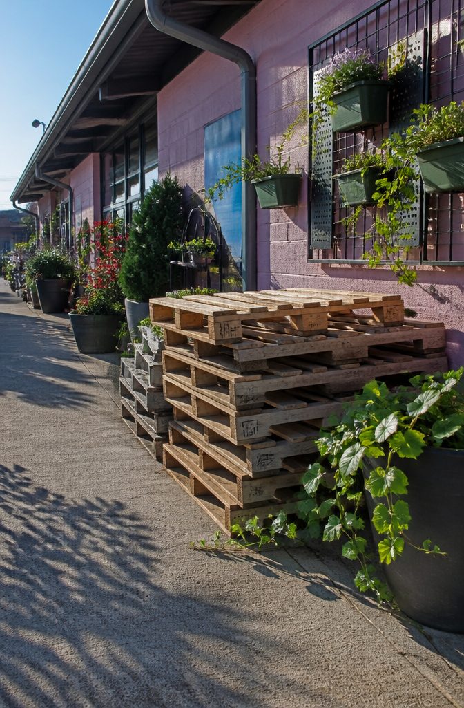 Stacks of pallets behind a store ready for pickup.