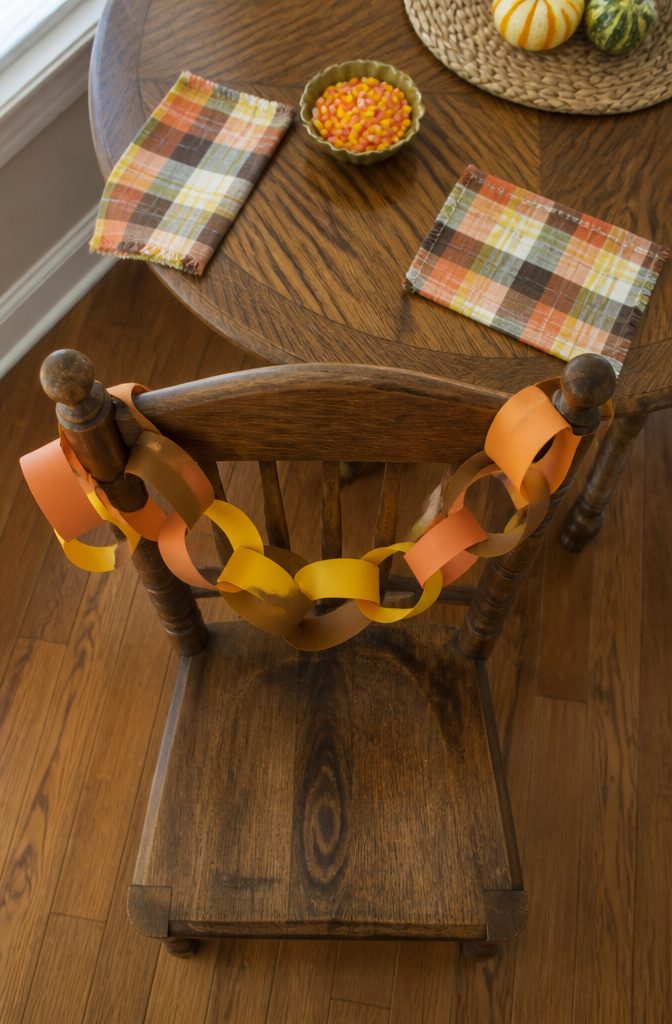 A paper chain countdown to Thanksgiving with orange, brown, and yellow loops.